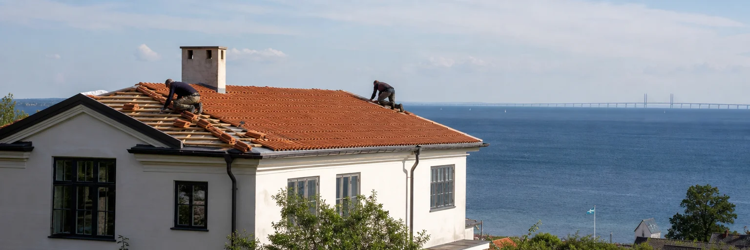 Takläggare arbetar på kustexponerat tegeltak i villakvarter i Helsingborg